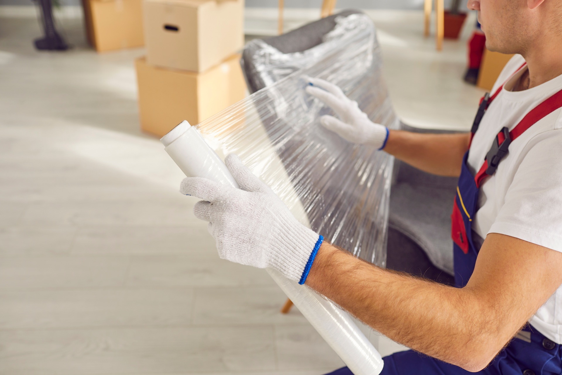 Mover wrapping a sofa in protective stretch film before a move