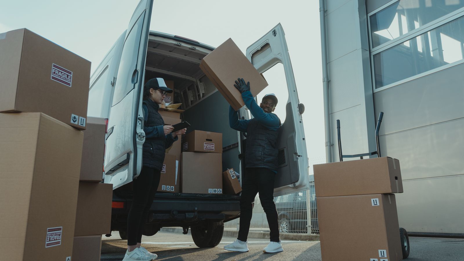Two movers loading boxes into an unbranded moving truck